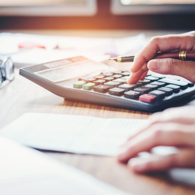 Businessman's hands with calculator and cost at the office and Financial data analyzing counting on wood desk