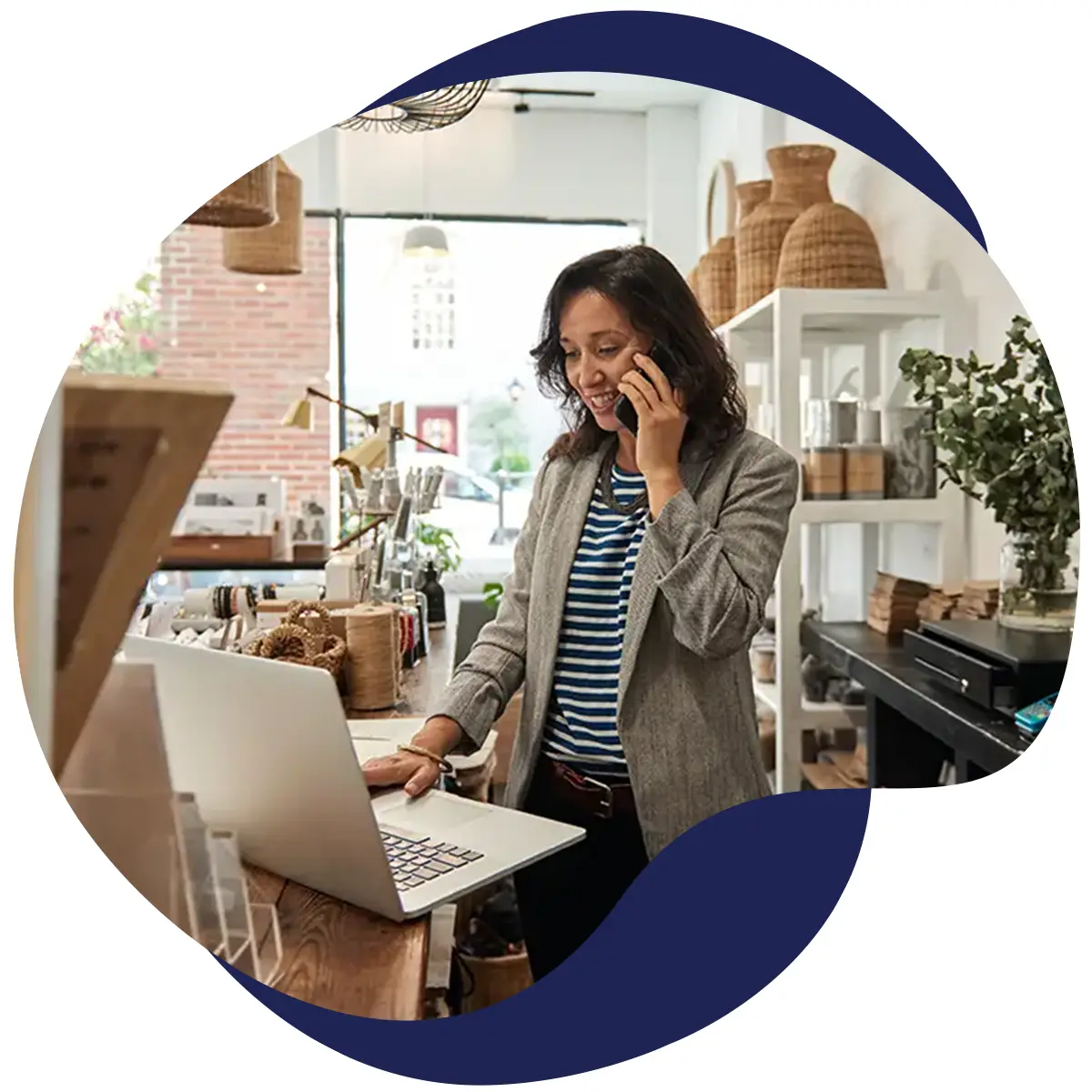 woman in a small shop taking a payment over the phone